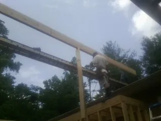 Carpenter setting a ridge beam over a new addition frame — Ice Dam Removal by Roofing Brothers in Honey Creek
