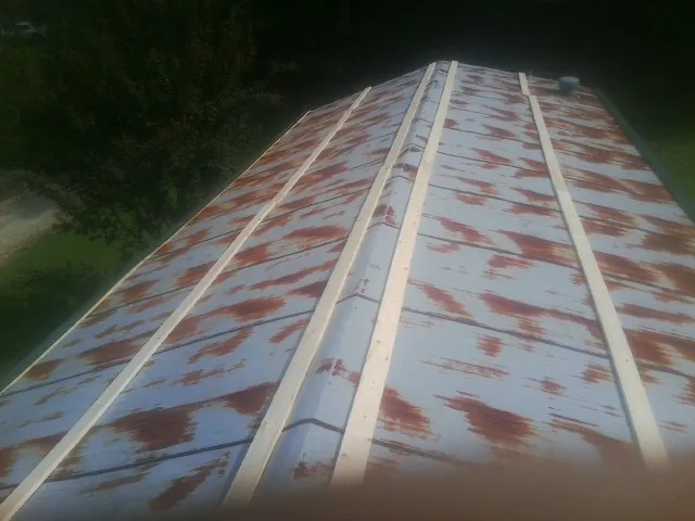Rusted metal roof panels with new wood purlins before replacement — Storm Damage Roof Repair in Honey Creek by Roofing Brothers
