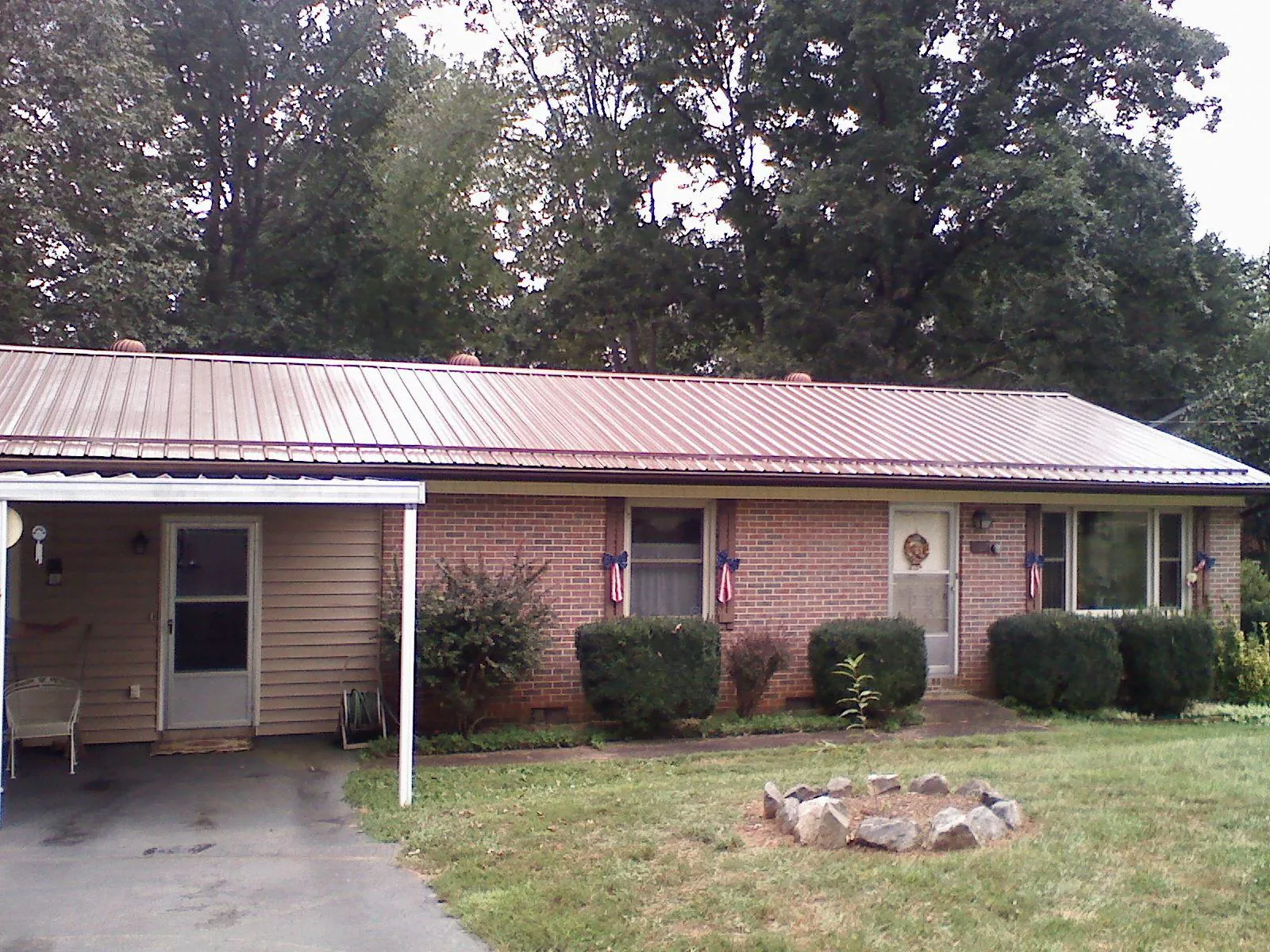 Bronze metal roof and carport on a brick ranch home — Roof Repair work by our crew in Honey Creek